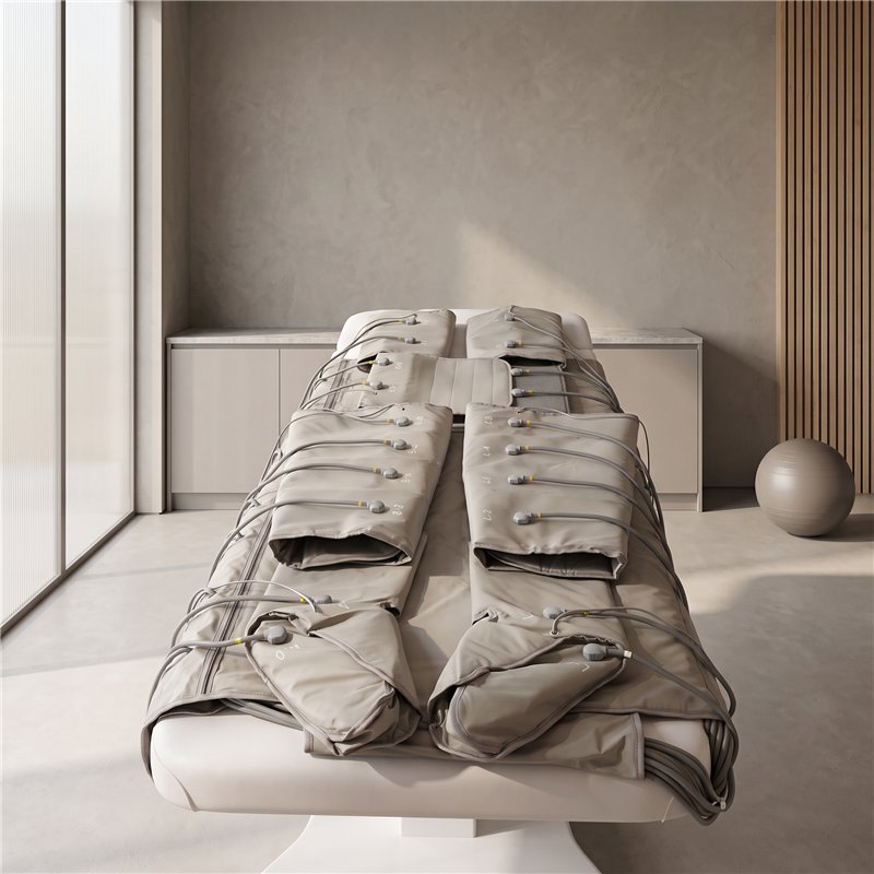 Modular pressotherapy body suit laid out on a treatment bed